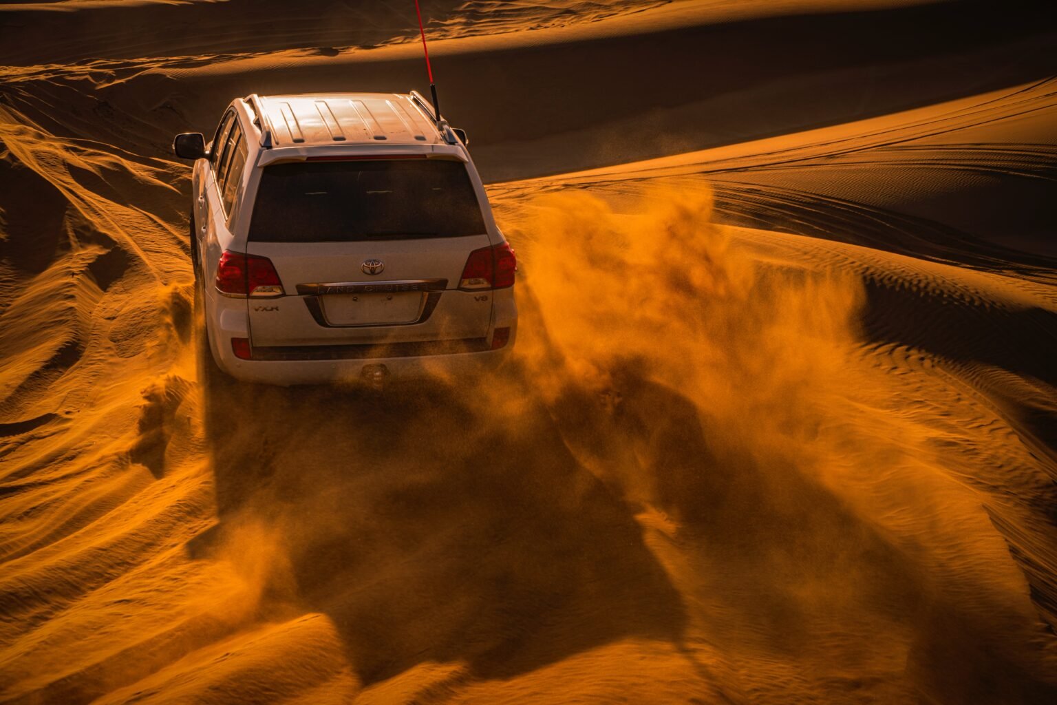 SUV in the Dubai desert at golden hour